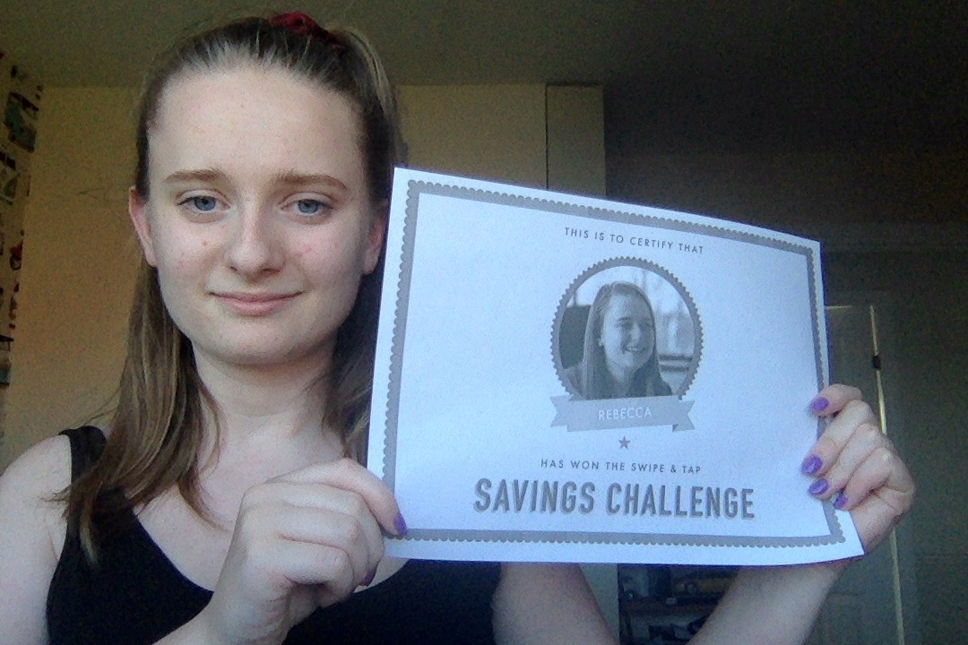 A photo of our web developer Rebecca holding a certificate for winning the Saving's Challenge.