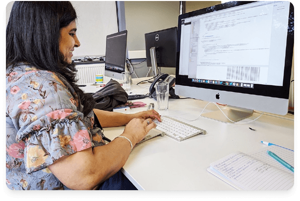 Software developer working at desk with multiple monitors